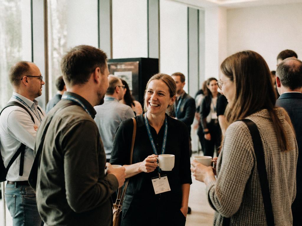 People chatting in small groups during a conference coffee break